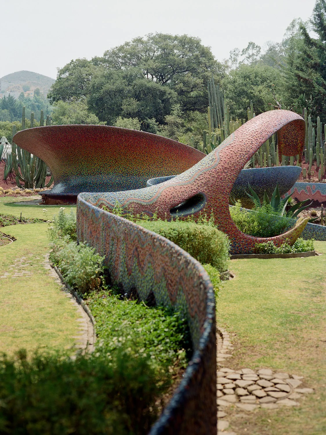 Weathering-steel landform sculpture set into a planted garden terrace